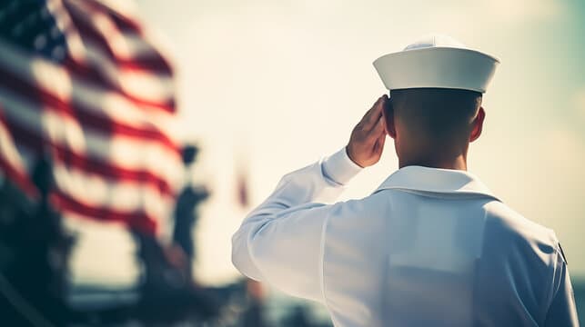 Naval service member saluting American flag